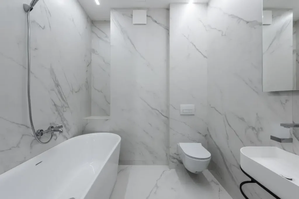 Modern bathroom featuring a sleek freestanding bathtub, shower with elegant fixtures, minimalist design, and marble walls, representing a stylish tub-to-shower conversion by Oasis Bathroom Remodeling Boca Raton.