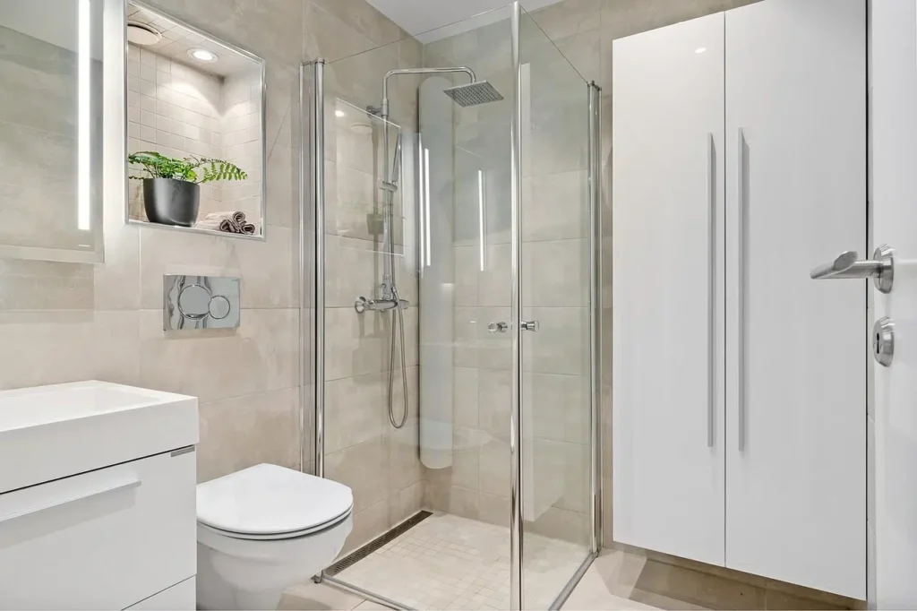 Custom Small Bathroom Oasis Bathroom Boca Raton Modern small bathroom renovation featuring a sleek glass shower, contemporary toilet, minimalist cabinetry, and stylish lighting, showcasing Oasis Bathroom Remodeling's expertise in maximizing space and functionality.