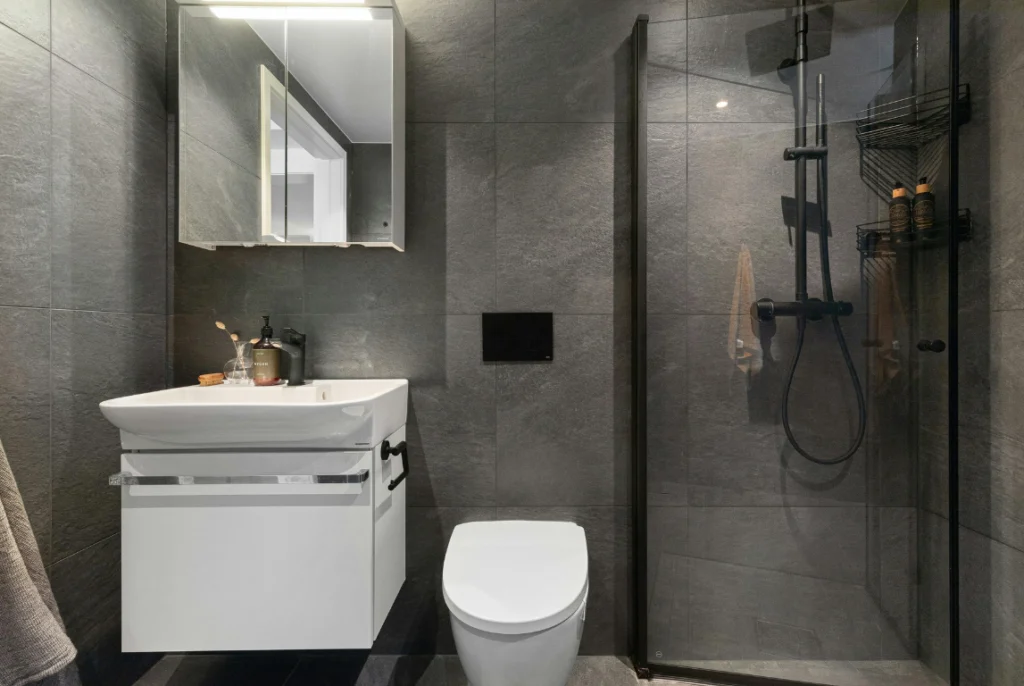 Modern Bathroom Remodeling Contractors Oasis Bathroom Boca Raton Modern bathroom design featuring a sleek white vanity with a basin, wall-mounted mirror, and a glass shower enclosure, showcasing contemporary fixtures and stylish gray tile accents.