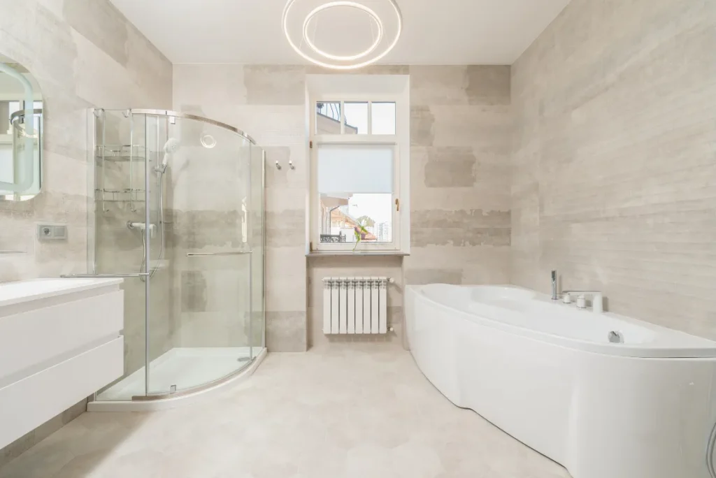 Modern Shower Remodel Oasis Bathroom Boca Raton Modern bathroom featuring a glass shower enclosure and freestanding tub, with neutral-toned walls and sleek fixtures, highlighting a stylish and functional shower remodel.