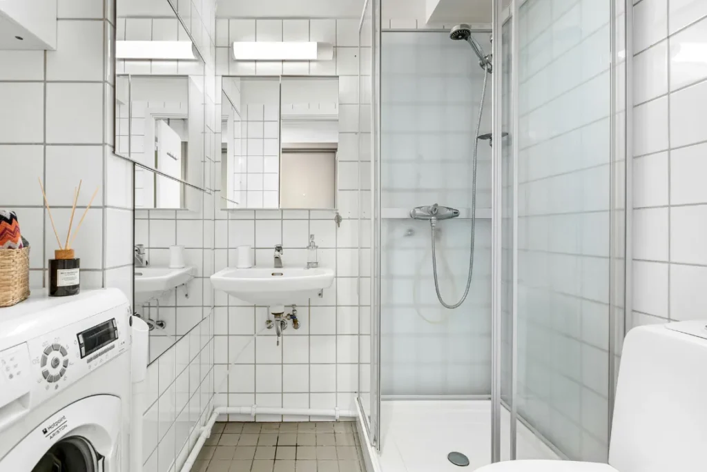 New Shower Remodel Oasis Bathroom Boca Raton Modern bathroom shower with glass enclosure, sleek fixtures, and white tile, showcasing a compact design ideal for efficient remodeling in Boca Raton.
