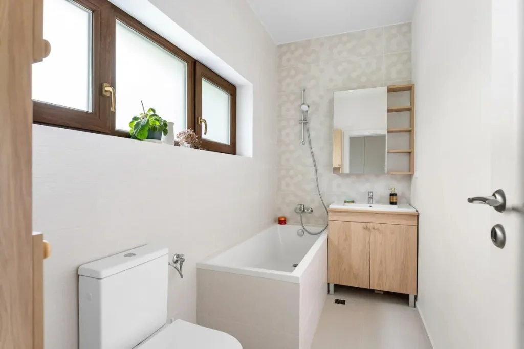 New Tub to Shower Conversion Oasis Bathroom Boca Raton Modern bathroom featuring a combination of a bathtub and shower, wooden cabinetry, natural light from windows, and stylish decor, illustrating an efficient tub-to-shower conversion space.