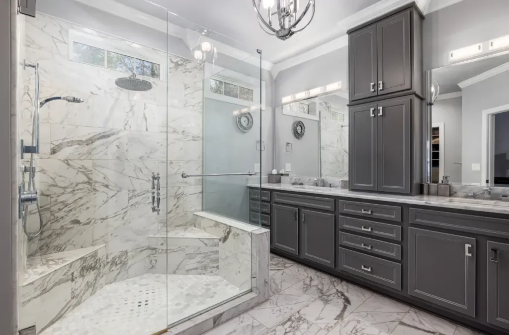 Practical Bathroom Renovation Oasis Bathroom Boca Raton Modern walk-in shower with marble-look tiles, glass enclosure, and gray cabinetry, showcasing a stylish bathroom renovation ideal for tub-to-shower conversions.
