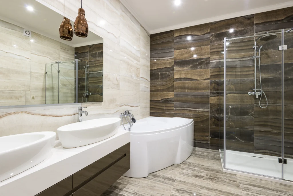 Transparent Bathroom Remodel Oasis Bathroom Boca Raton Modern bathroom featuring a sleek jacuzzi tub, dual vessel sinks, elegant pendant lighting, and a glass shower enclosure with stylish wall tiles, illustrating high-quality design for affordable bathroom remodel solutions.