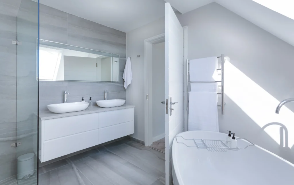 White Bathroom Remodeling Contractors Oasis Bathroom Boca Raton Modern bathroom interior featuring a double sink vanity, sleek faucets, and a freestanding bathtub, emphasizing contemporary design and functionality for remodeling projects in Boca Raton.