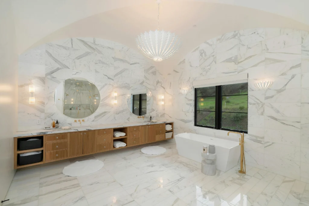 White Bathroom model Oasis Bathroom Boca Raton Luxurious white bathroom featuring a freestanding jacuzzi tub, marble walls, double mirrors, and elegant lighting, showcasing high-end design for remodeling services in Boca Raton.