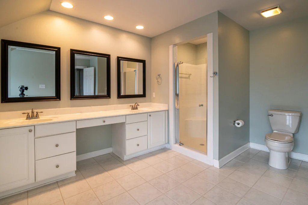 Wide Bathroom Renovation Oasis Bathroom Boca Raton Spacious modern bathroom featuring dual sinks, elegant mirrors, a walk-in shower, and a toilet, designed for efficient small bathroom renovations by Oasis Bathroom Remodeling Boca Raton.